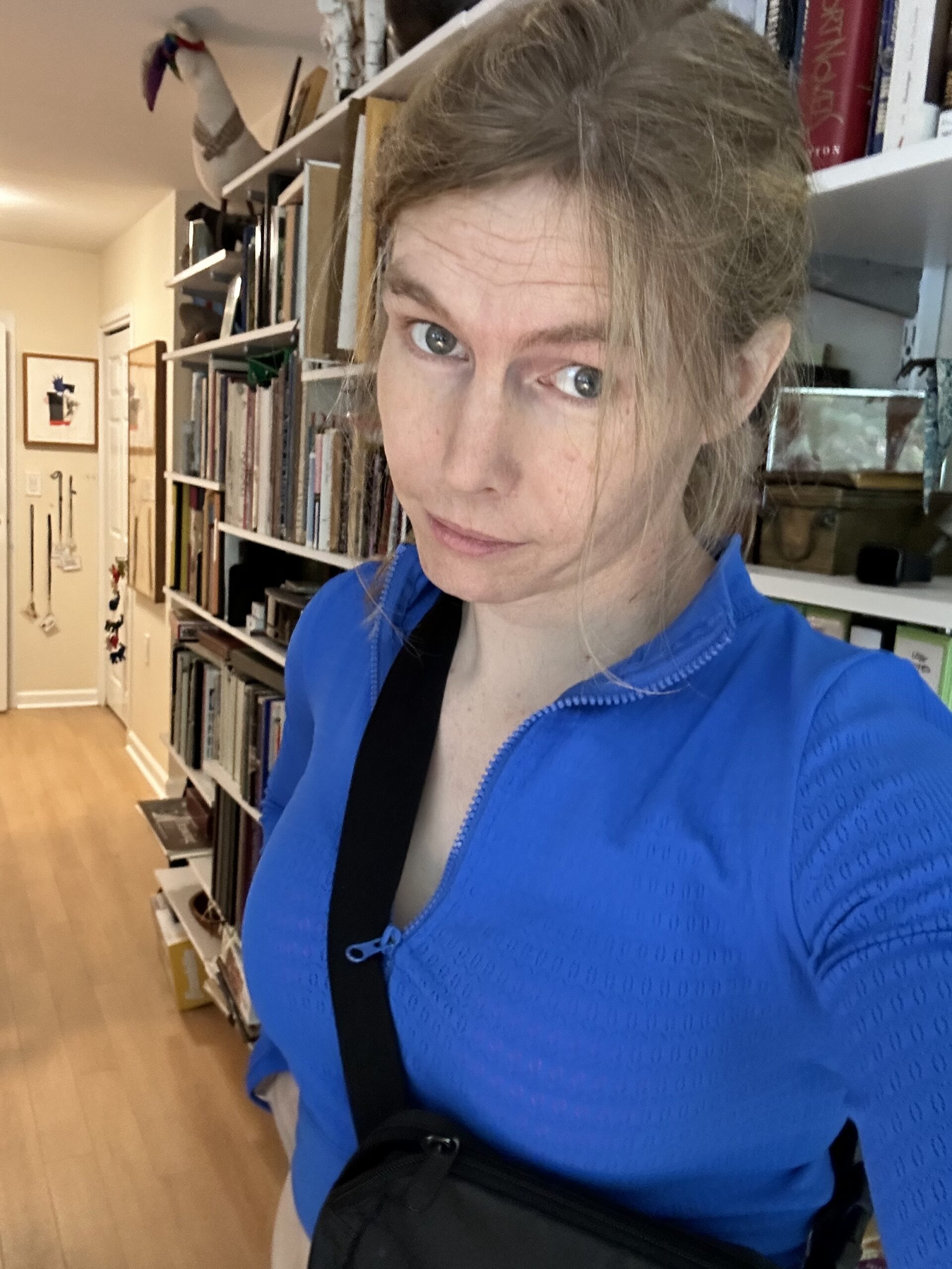 Picture of Megan Eza in a Blue fit with a cross body bag and hair tied back.